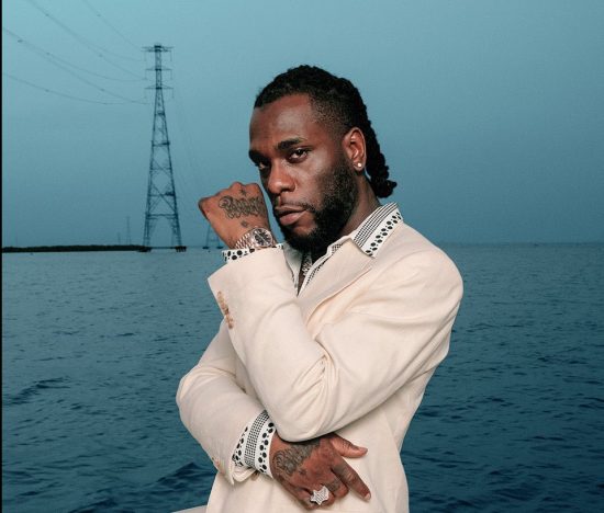 Burna Boy calls himself an interior decorator as he sprays money on the ground